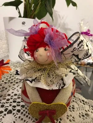 Muñeca con lazos lilas y corazón dorado
