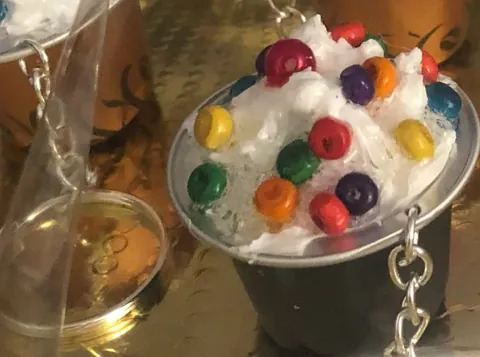 Llaveros hechos con cápsulas, rellenos de blanco y bolitas de colores