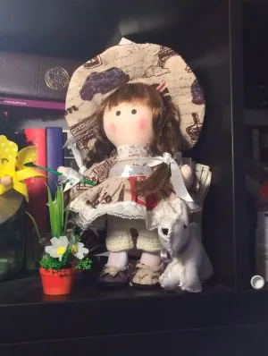 Muñeca con sombrero estampado y un perrito blanco